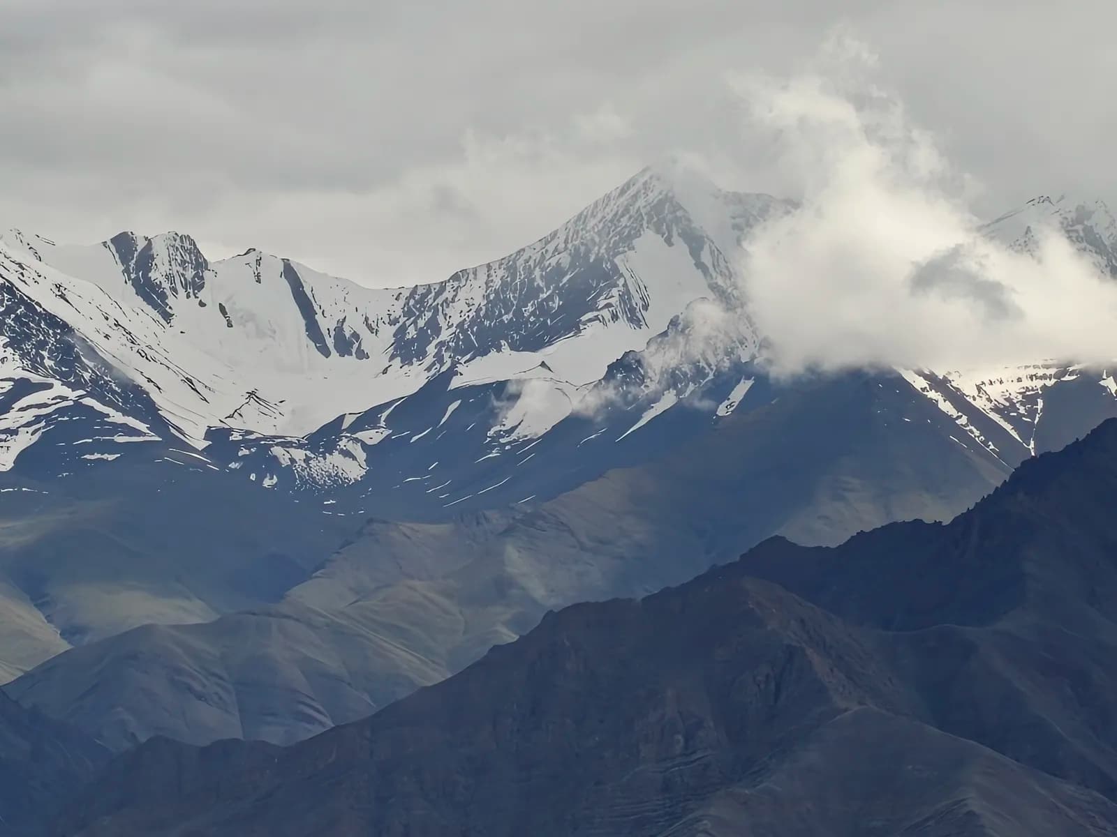Snow peaks above Leh under moody clouds