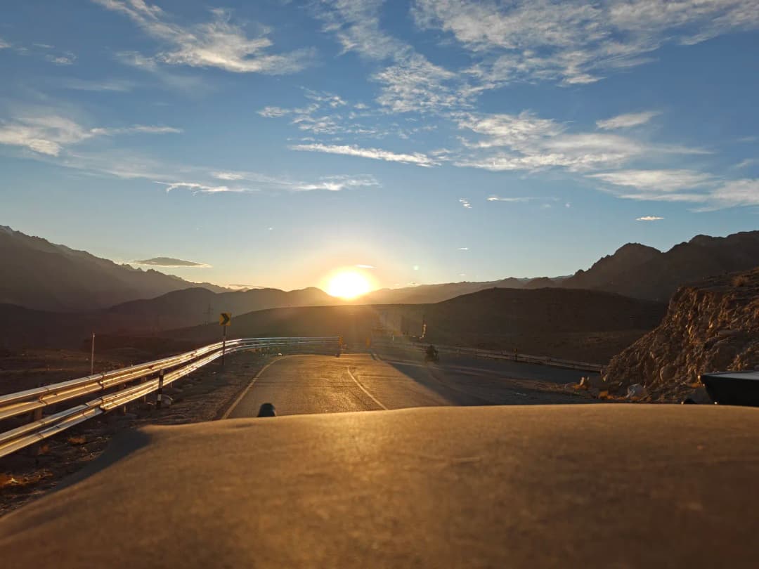 View over the bonnet driving into a Ladakh sunset