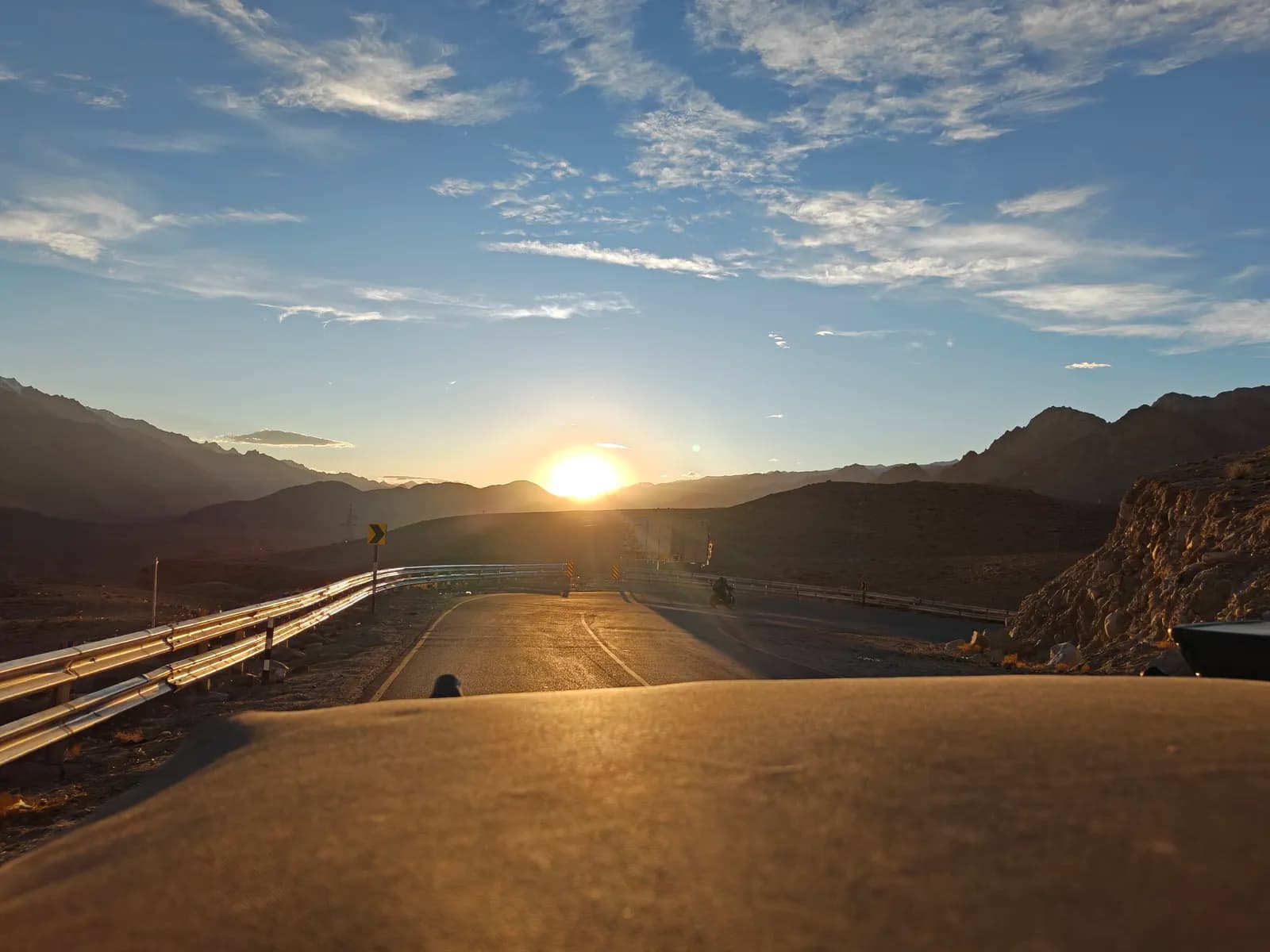 Sunset over the highway from behind the wheel in Ladakh